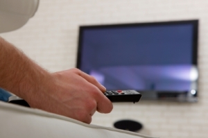 Man Watching TV With Remote Control